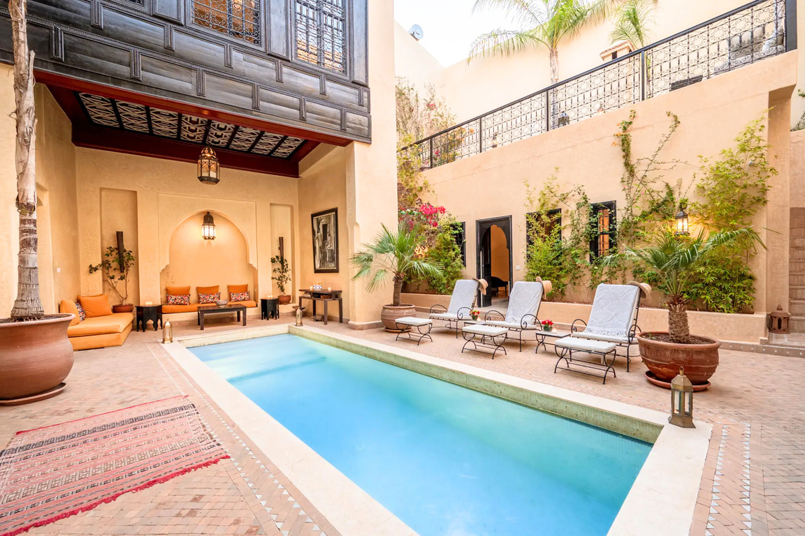 Cour intérieure du riad avec piscine et transats à Marrakech